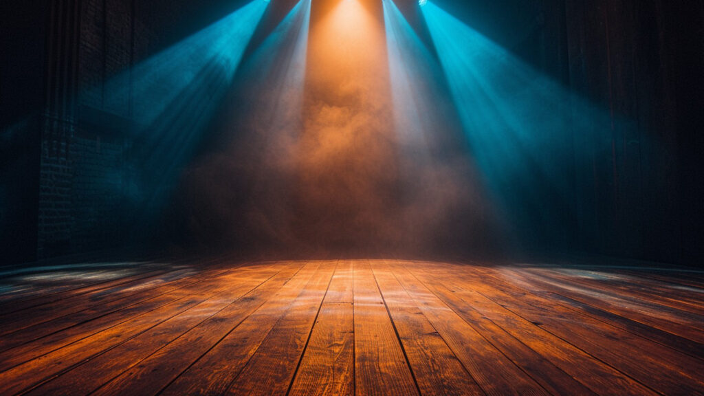 Empty theater stage with dramatic spotlights setting the atmosphere for a stage hypnosis performance
